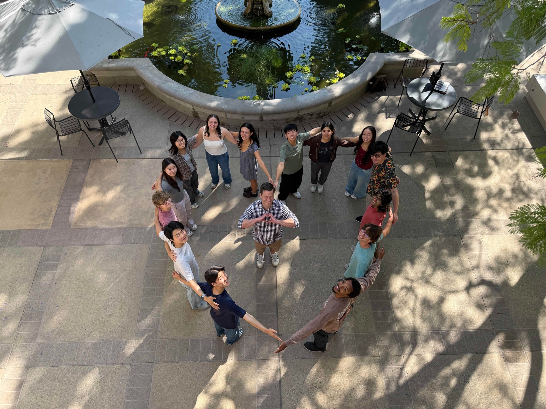 Overhead view of the PoSM Lab group forming a heart in the courtyard